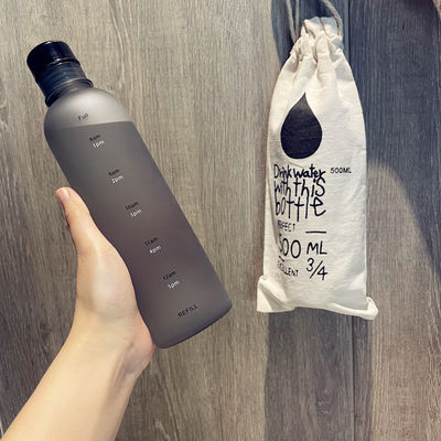 Une bouteille d'eau en plastique de 500 ml pour le gymnase avec une échelle de temps pour le fitness moderne et un design réutilisable