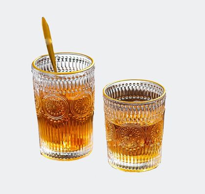 Une tasse en verre à bord en or avec un design en tournesol et un style classique.