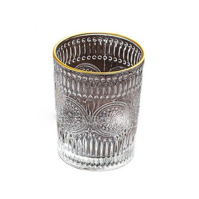 Une tasse en verre à bord en or avec un design en tournesol et un style classique.