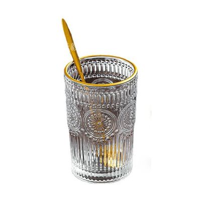 Une tasse en verre à bord en or avec un design en tournesol et un style classique.