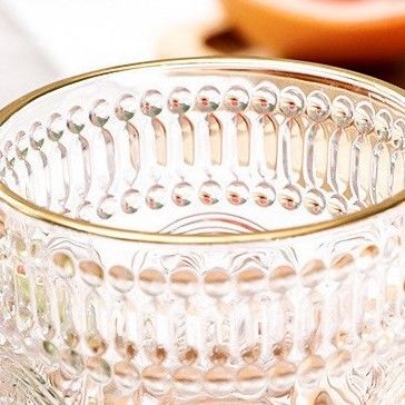 Une tasse en verre à bord en or avec un design en tournesol et un style classique.