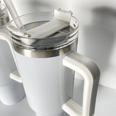 Une tasse de voyage isolée en acier inoxydable avec poignée de logo personnalisé plus chaude, plus colorée et plus sûre